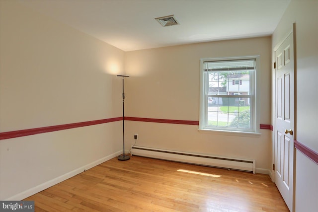 unfurnished room with baseboards, baseboard heating, light wood finished floors, and visible vents