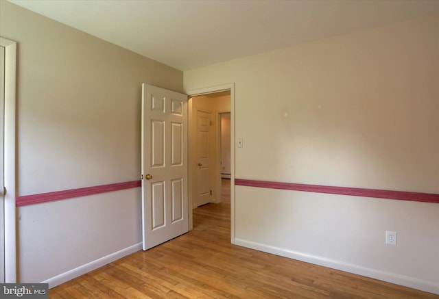 empty room with baseboards and wood finished floors