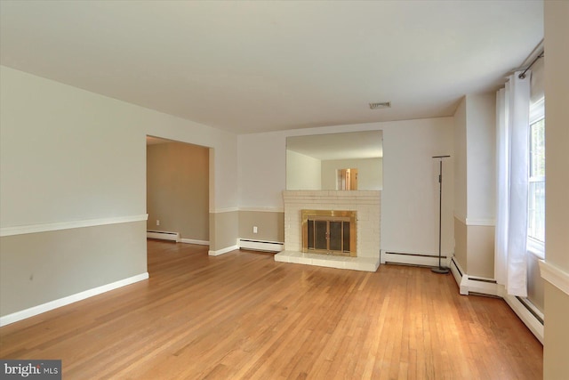 unfurnished living room with visible vents, light wood-style flooring, and baseboard heating