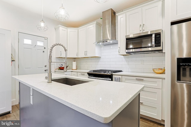 2325 W Thompson St, Philadelphia, PA 19121 - kitchen with tasteful backsplash, a sink, wall chimney exhaust hood, stainless steel appliances, and light wood-type flooring