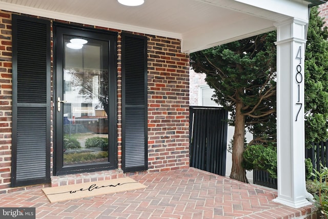 entrance to property with brick siding and covered porch