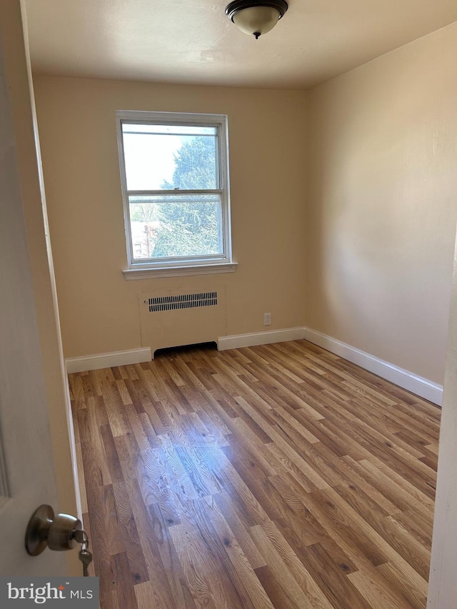 577 Snowden Rd, Upper Darby, PA 19082 - unfurnished room featuring baseboards, radiator heating unit, and wood finished floors
