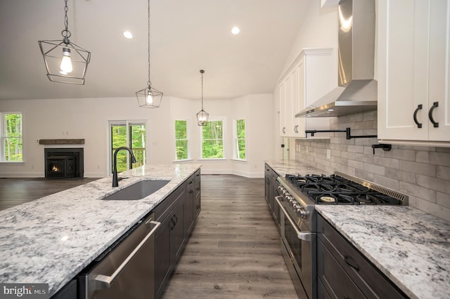 9343 Troy Dr, Nokesville, VA 20181 - kitchen featuring light stone countertops, wall chimney exhaust hood, white cabinetry, a sink, and appliances with stainless steel finishes