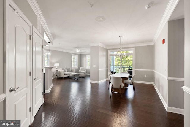 dining room with crown molding, baseboards, dark wood-type flooring, and a notable chandelier
