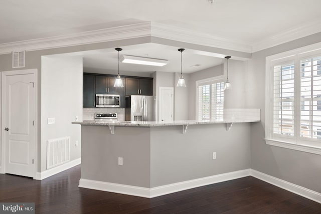 kitchen featuring appliances with stainless steel finishes, light stone countertops, a kitchen bar, and visible vents