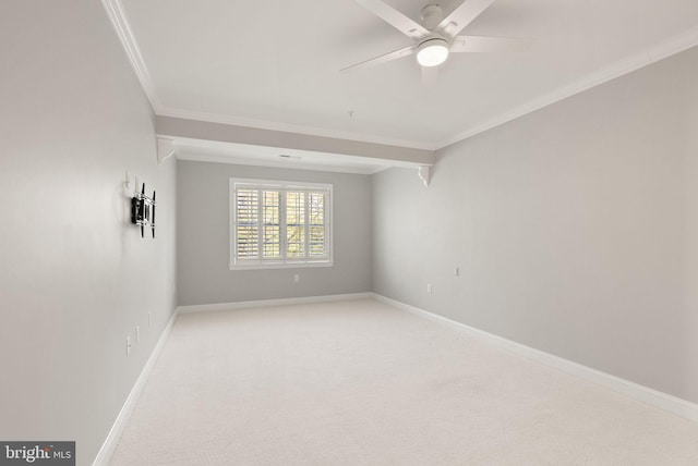 spare room with baseboards, ornamental molding, ceiling fan, and light colored carpet