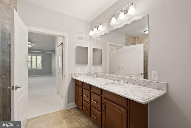 full bath featuring double vanity, a sink, a ceiling fan, and a tile shower
