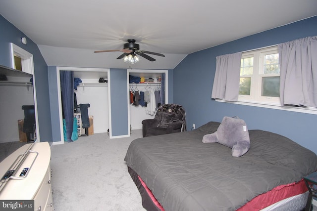 bedroom with carpet flooring, a ceiling fan, and multiple closets