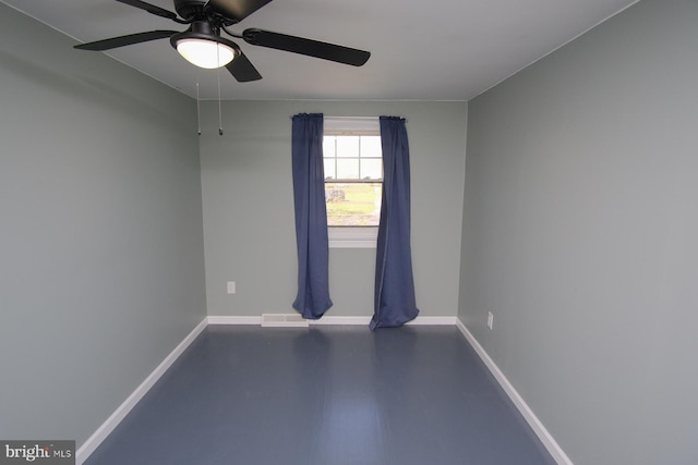 unfurnished room featuring baseboards, finished concrete flooring, ceiling fan, and visible vents