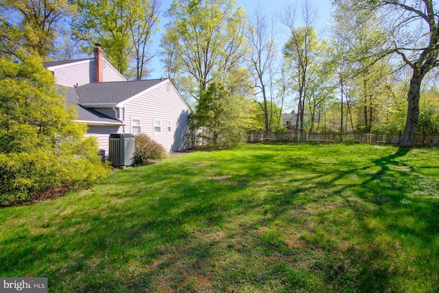 view of yard featuring central AC unit and fence