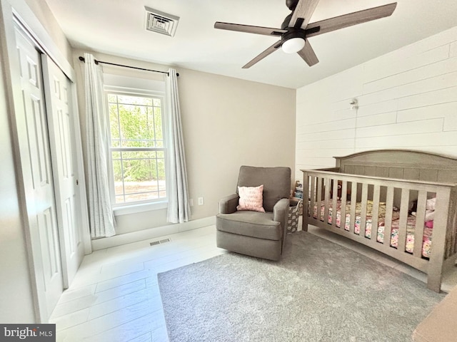 bedroom featuring a crib and a ceiling fan