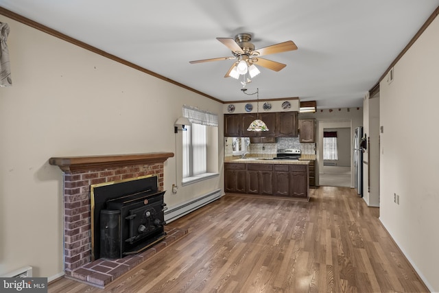 48 Dunstable Rd, Southampton, NJ 08088 - kitchen with a baseboard radiator, dark brown cabinetry, a wood stove, light countertops, and wood finished floors