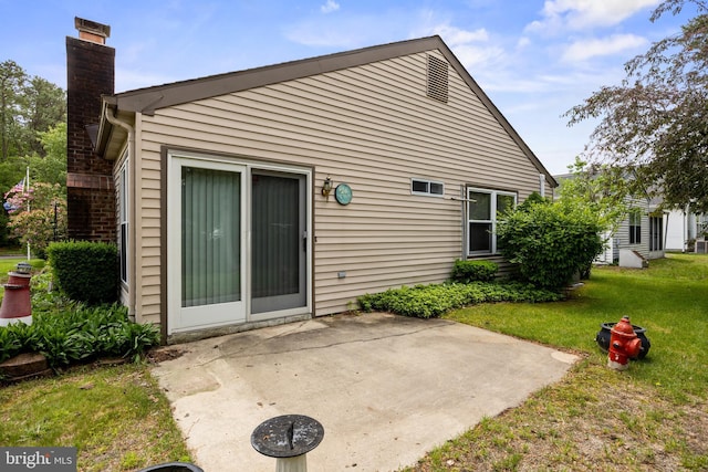 48 Dunstable Rd, Southampton, NJ 08088 - back of property with a chimney, a patio, and a lawn