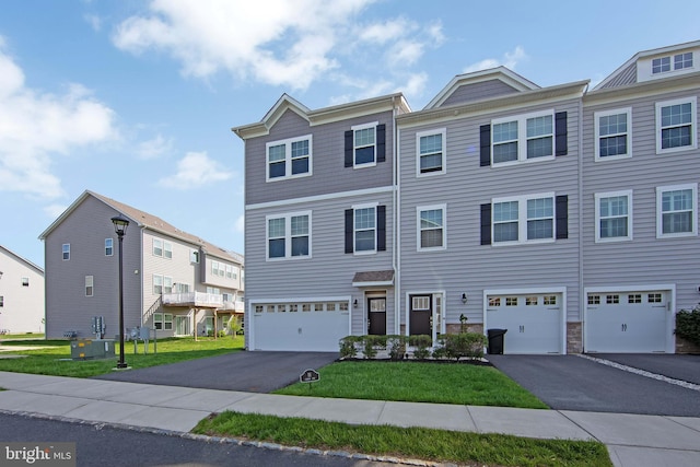 view of front of house featuring driveway, a front yard, and a garage