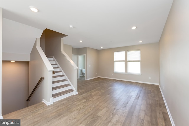 interior space with recessed lighting, baseboards, wood finished floors, and stairway