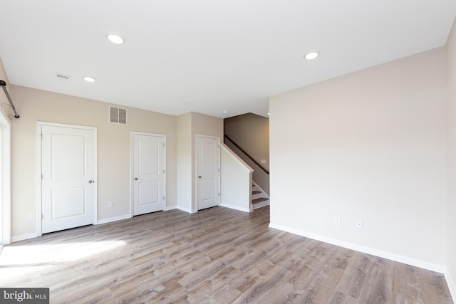 interior space featuring light wood-style floors, baseboards, recessed lighting, and visible vents