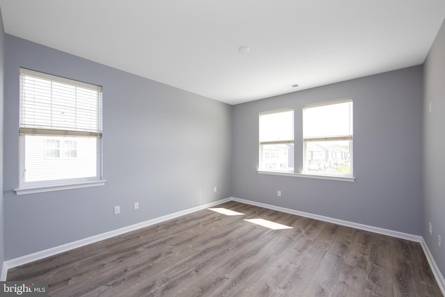 empty room with baseboards and wood finished floors