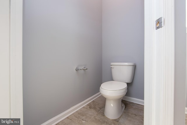 bathroom with baseboards, tile patterned floors, and toilet