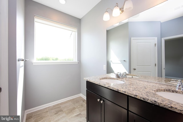 bathroom featuring double vanity, baseboards, visible vents, and a sink