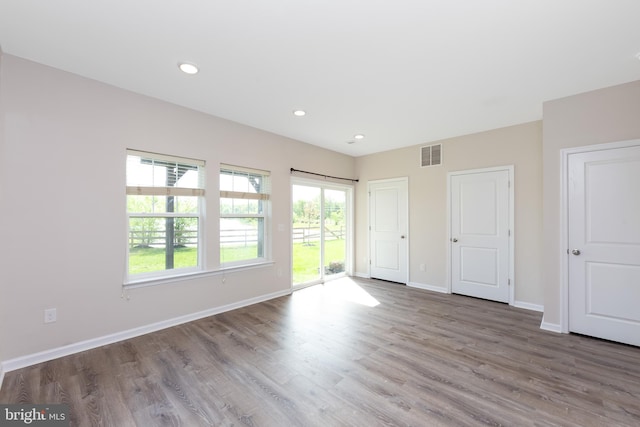 unfurnished bedroom with visible vents, wood finished floors, access to exterior, baseboards, and recessed lighting