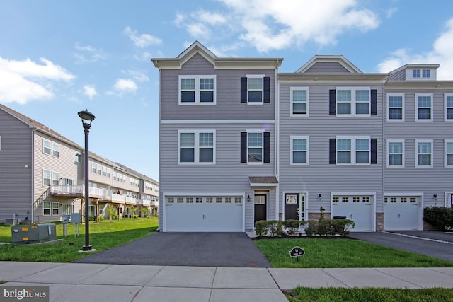 view of front of house featuring an attached garage, a front lawn, central AC, and driveway