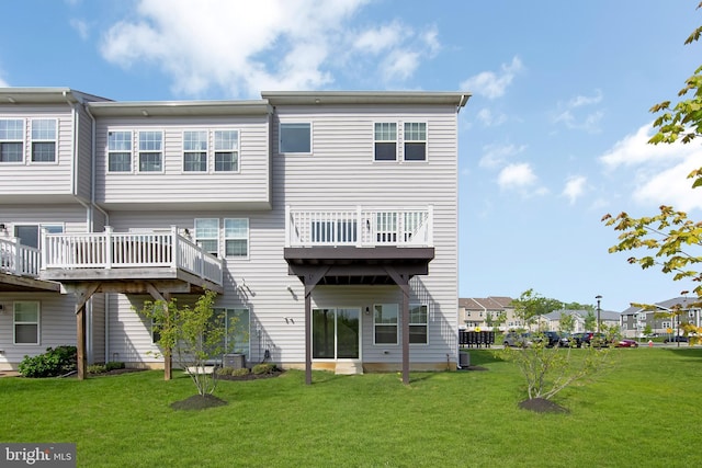 back of house featuring a lawn, central AC unit, and a residential view