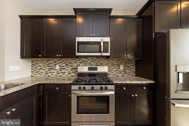 kitchen featuring backsplash, stainless steel appliances, and dark brown cabinetry