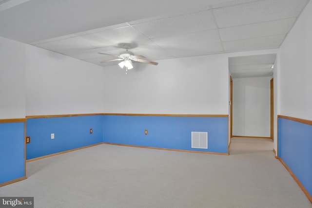 unfurnished room with carpet floors, a ceiling fan, a paneled ceiling, and visible vents