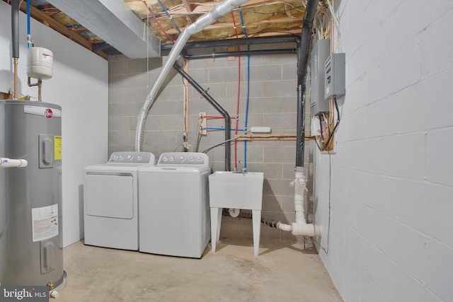 unfinished basement featuring water heater, concrete block wall, and washing machine and dryer