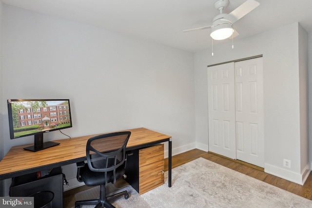 office space with a ceiling fan, baseboards, and wood finished floors
