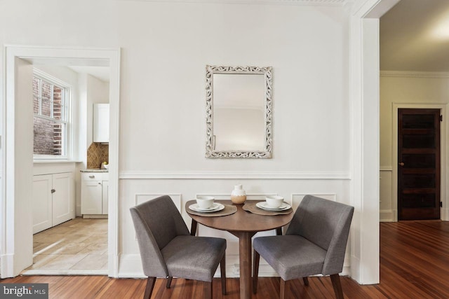 dining area featuring crown molding and light wood-style flooring