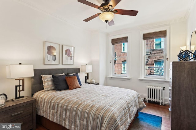 bedroom featuring baseboards, radiator, ceiling fan, and wood finished floors