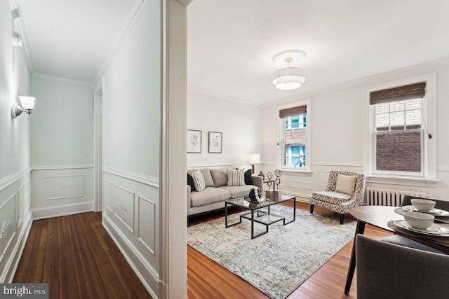 living room with ornamental molding, dark wood finished floors, radiator heating unit, and wainscoting