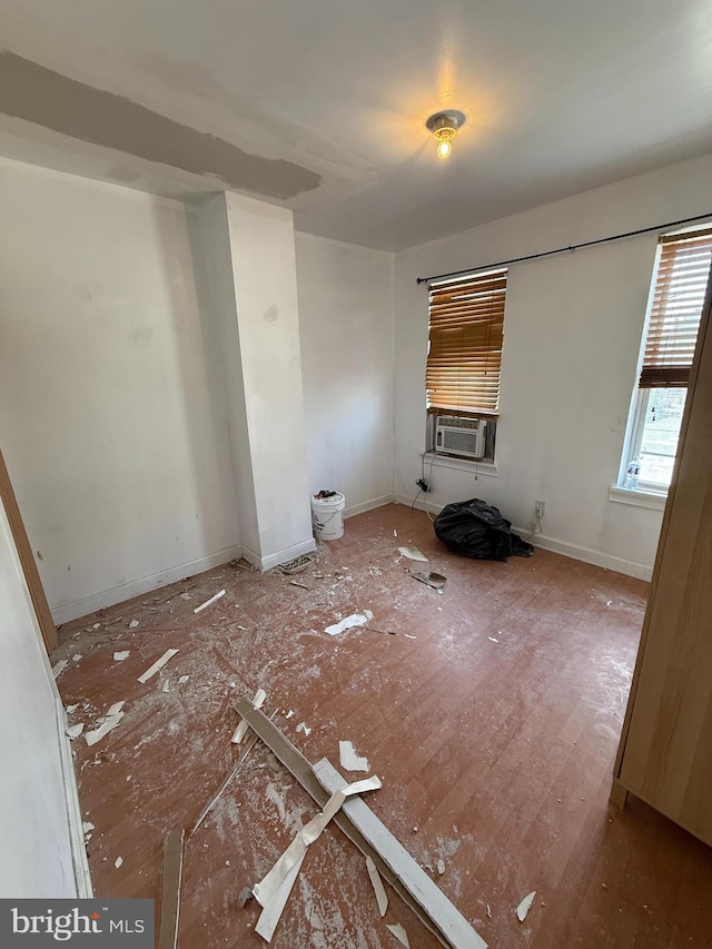 empty room with baseboards and cooling unit