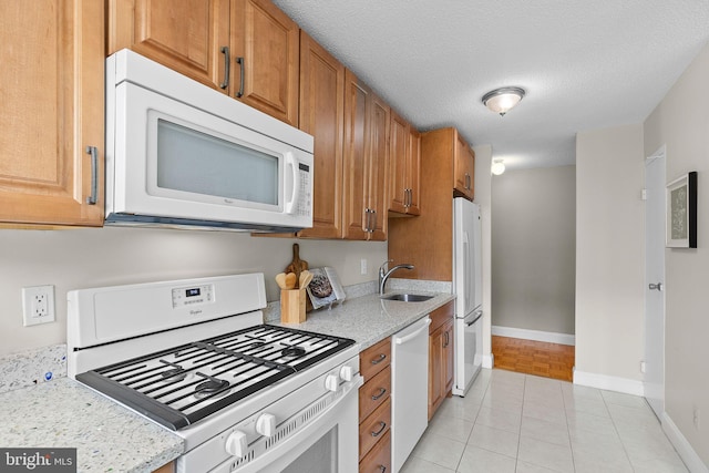 1301 S Arlington Ridge Rd Unit 208, Arlington, VA 22202 - kitchen with white appliances, a sink, light tile patterned floors, baseboards, and brown cabinetry