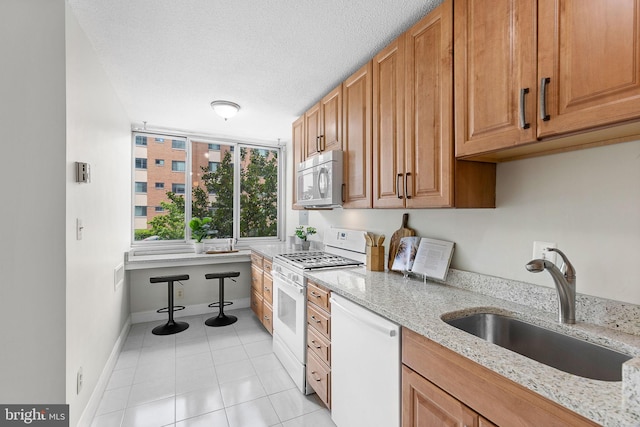 1301 S Arlington Ridge Rd Unit 208, Arlington, VA 22202 - kitchen with white appliances, a sink, light tile patterned floors, light stone countertops, and a textured ceiling