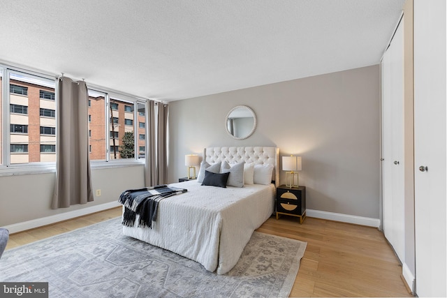 1301 S Arlington Ridge Rd Unit 208, Arlington, VA 22202 - bedroom featuring light wood-type flooring, baseboards, and a textured ceiling