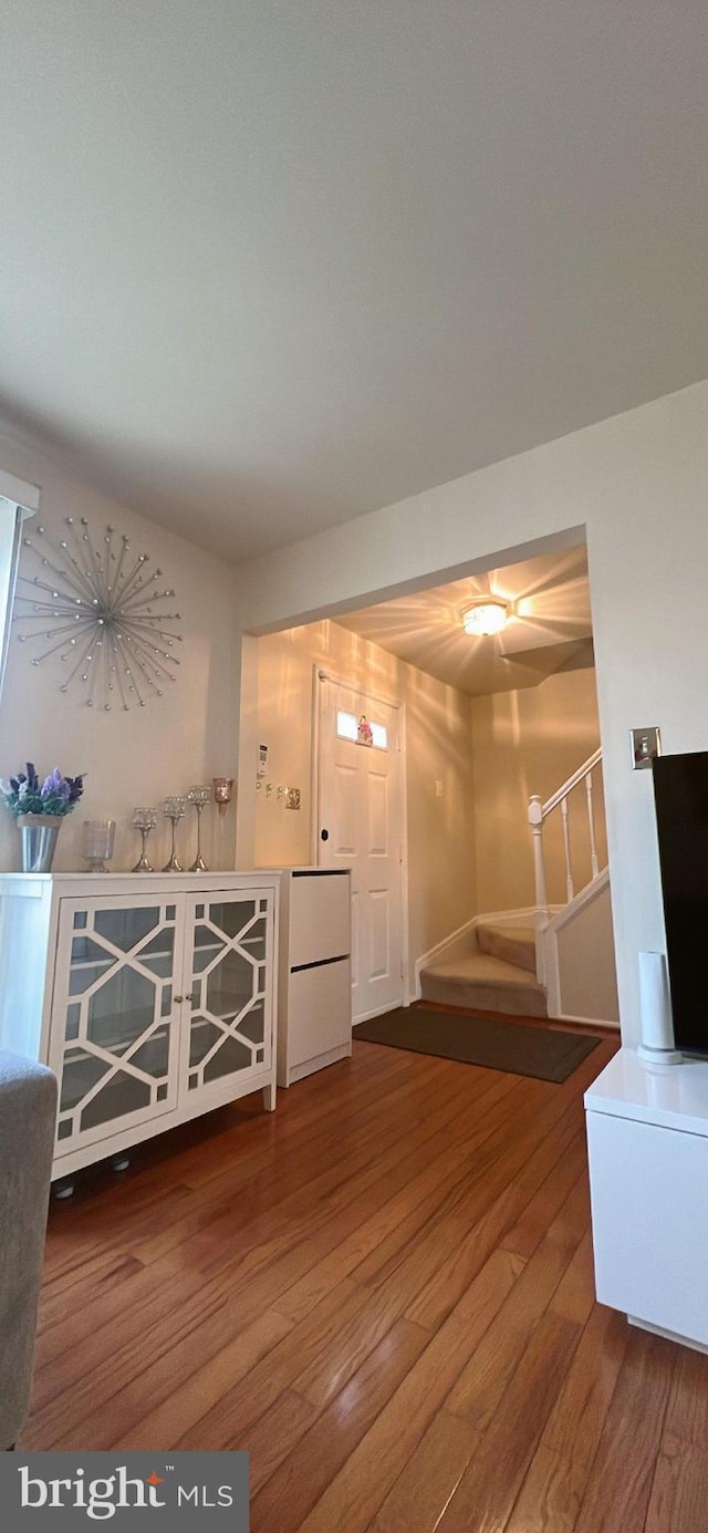 unfurnished living room with hardwood / wood-style flooring and stairs