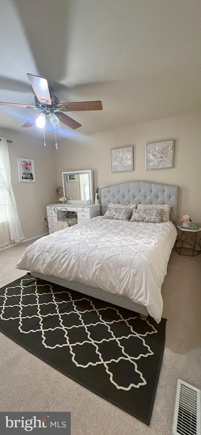 carpeted bedroom with visible vents and a ceiling fan