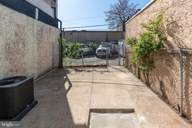 exterior space featuring a gate, fence, and cooling unit