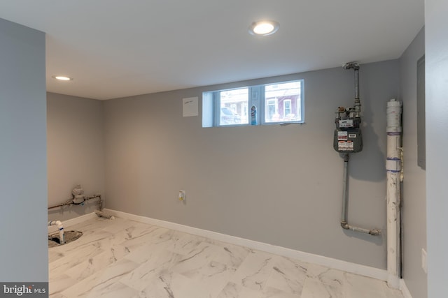 below grade area with baseboards, recessed lighting, and marble finish floor