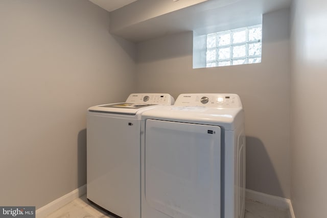 laundry area featuring baseboards, laundry area, marble finish floor, and washing machine and clothes dryer