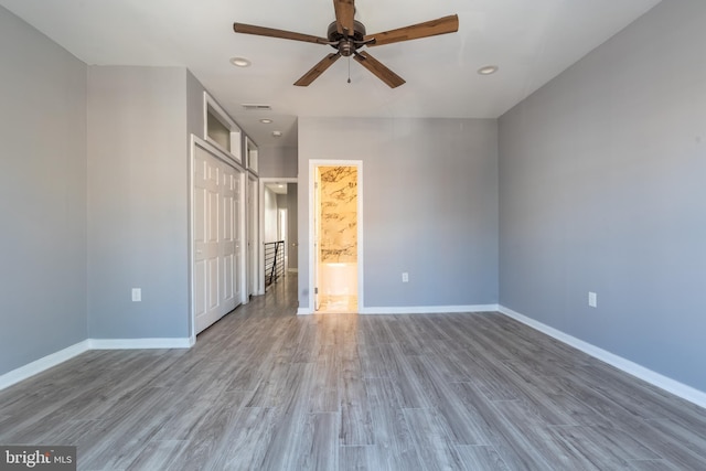unfurnished bedroom with baseboards, recessed lighting, wood finished floors, and visible vents