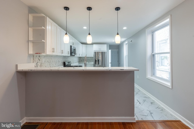 kitchen featuring open shelves, stainless steel appliances, white cabinetry, a peninsula, and backsplash