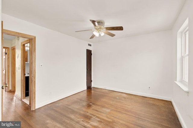 unfurnished room featuring visible vents, baseboards, ceiling fan, and wood finished floors
