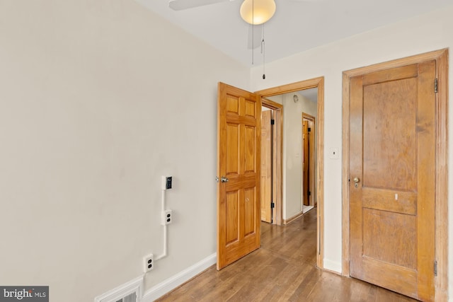 spare room with baseboards, ceiling fan, and light wood-type flooring