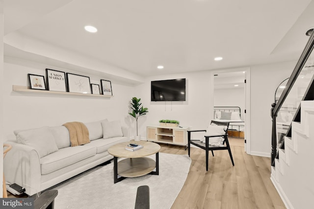 living area with recessed lighting, baseboards, and light wood-type flooring