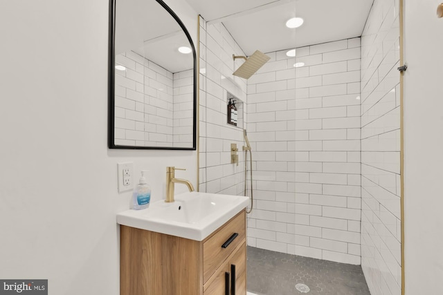 bathroom featuring recessed lighting, tiled shower, and vanity