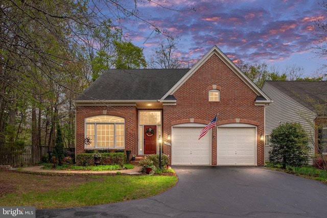 13073 Taverner Loop, Woodbridge, VA 22192 - traditional-style home featuring a garage, aphalt driveway, fence, roof with shingles, and brick siding