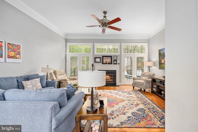 13073 Taverner Loop, Woodbridge, VA 22192 - living area featuring plenty of natural light, a fireplace with flush hearth, a ceiling fan, and wood finished floors